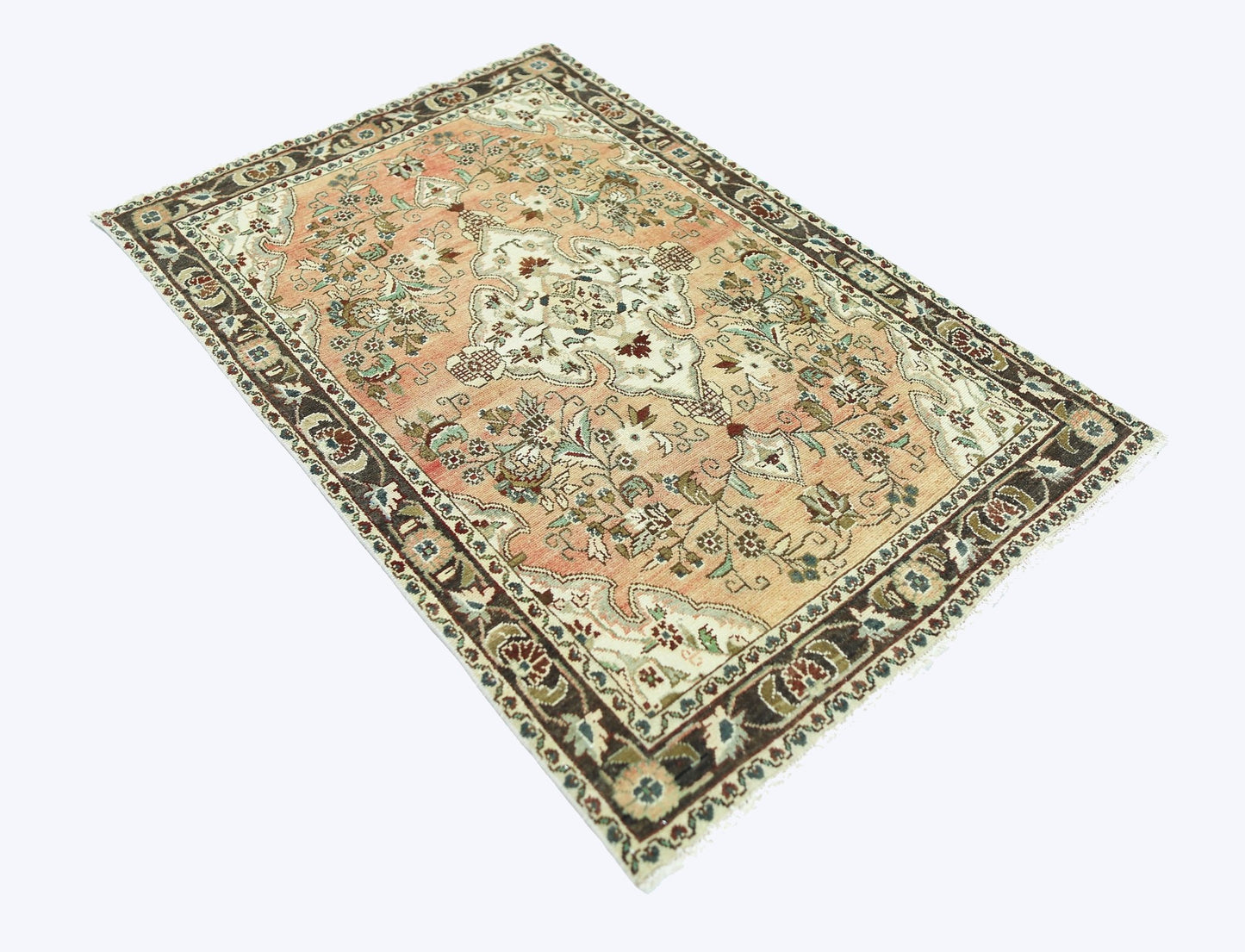 A vintage Persian Sarouk rug featuring a floral pattern in peach, cream, and dark brown tones.