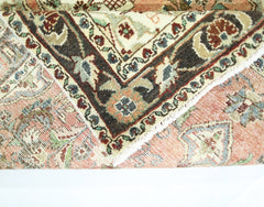 A folded vintage Persian Sarouk rug featuring intricate floral patterns in red, blue, and cream.