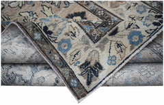 A vintage handwoven Persian Sarouk rug featuring a worn floral pattern in blue and beige tones.