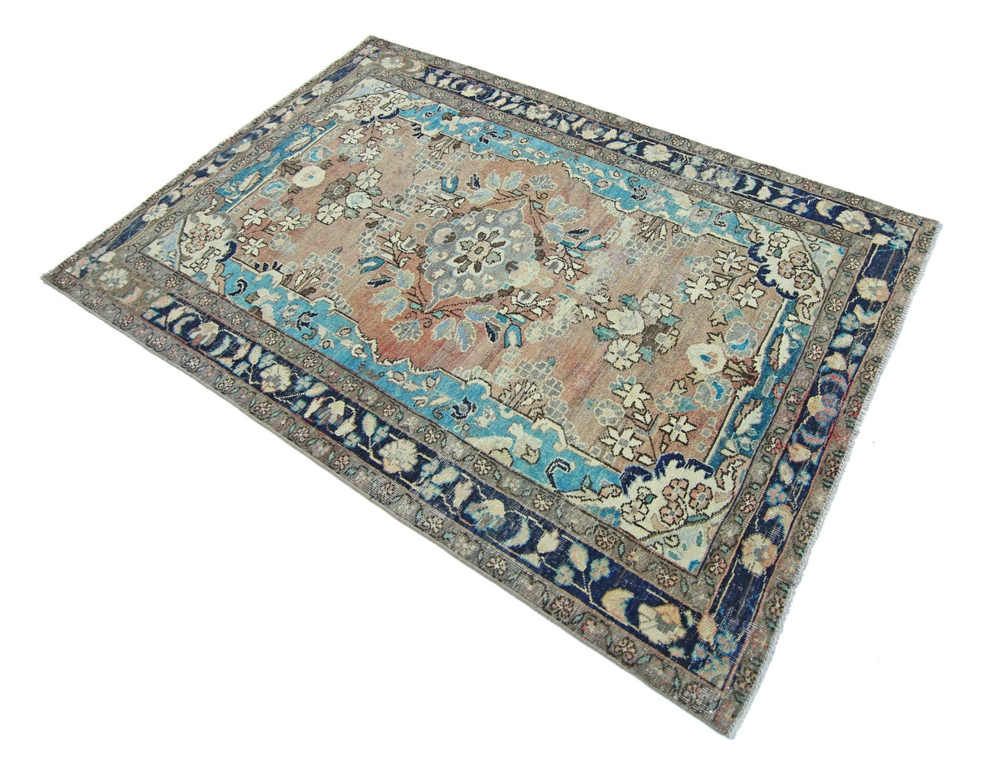 A vintage Persian Tabriz rug featuring a floral medallion pattern in blue and muted earth tones.