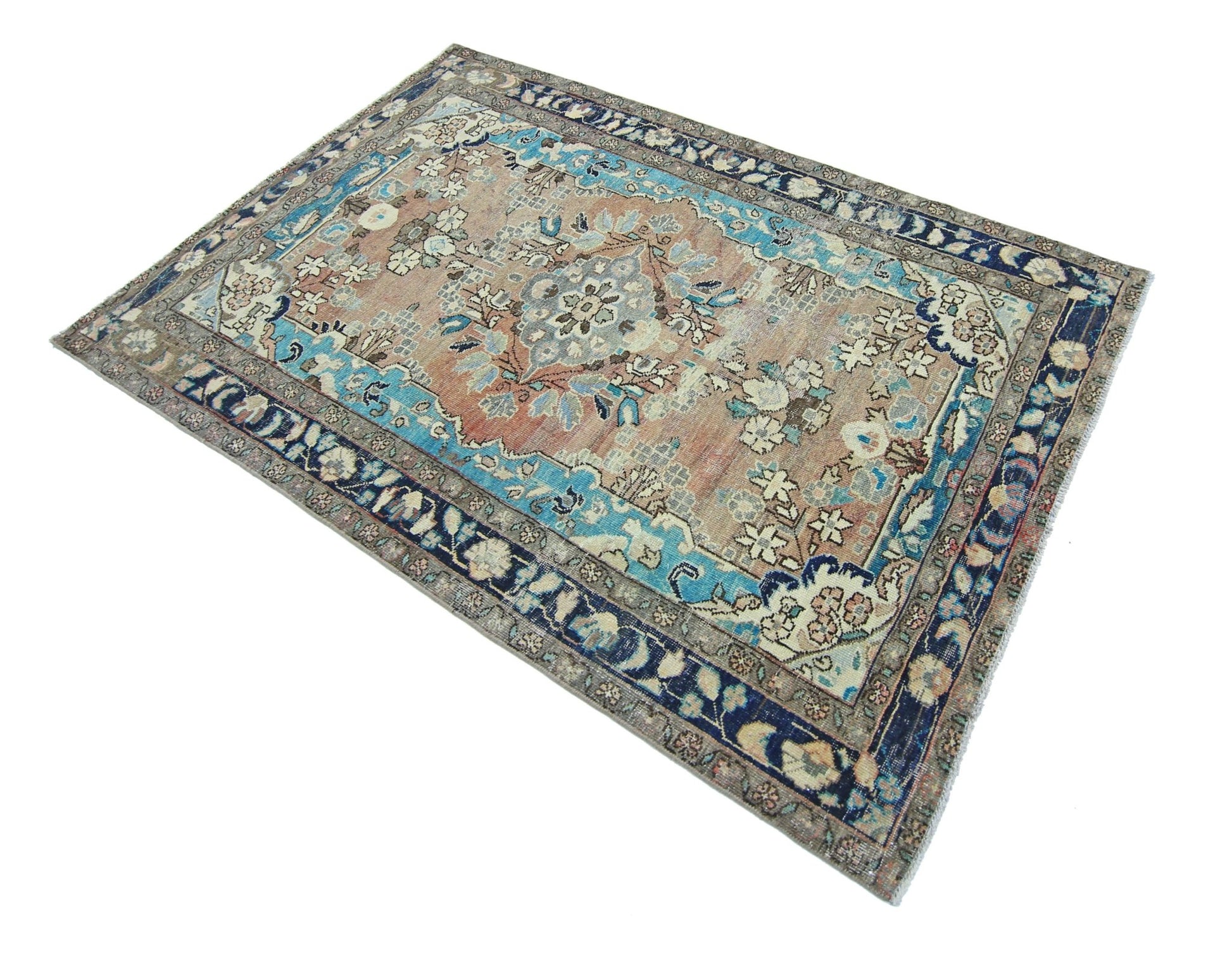 A vintage Persian Tabriz rug featuring a floral medallion pattern in blue and muted earth tones.