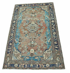 A vintage handmade Persian Tabriz rug featuring a floral medallion pattern in blue and terracotta.