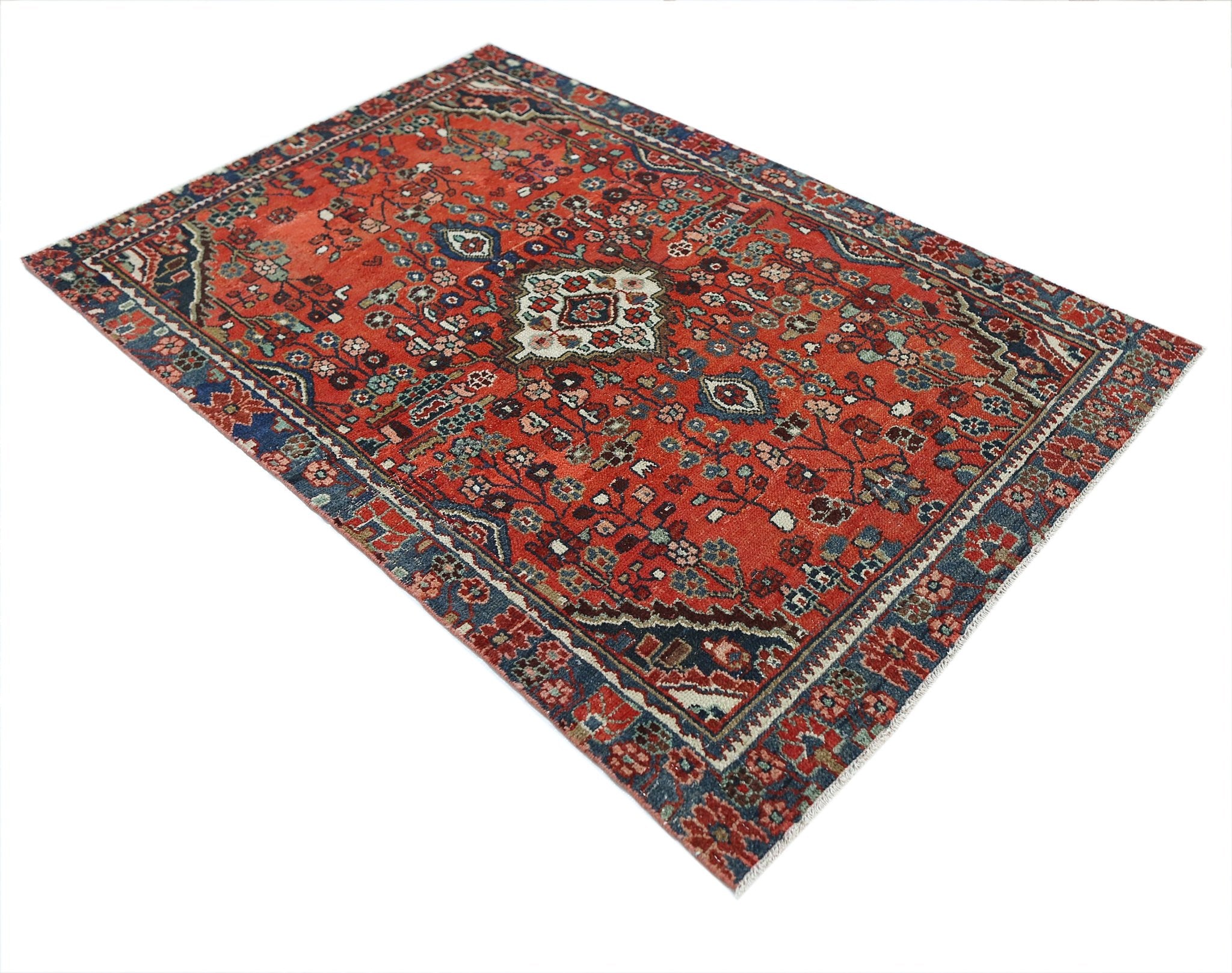 A vintage handmade Persian Sarouk rug featuring a floral pattern in red and blue tones.