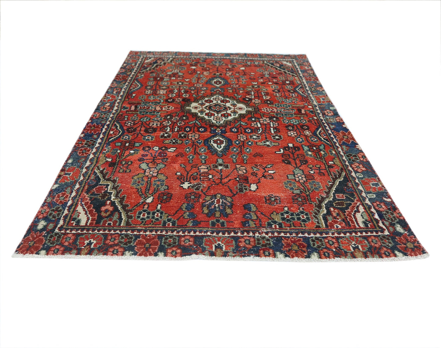 A vintage Persian Sarouk rug featuring a floral pattern in red, blue, and cream tones.