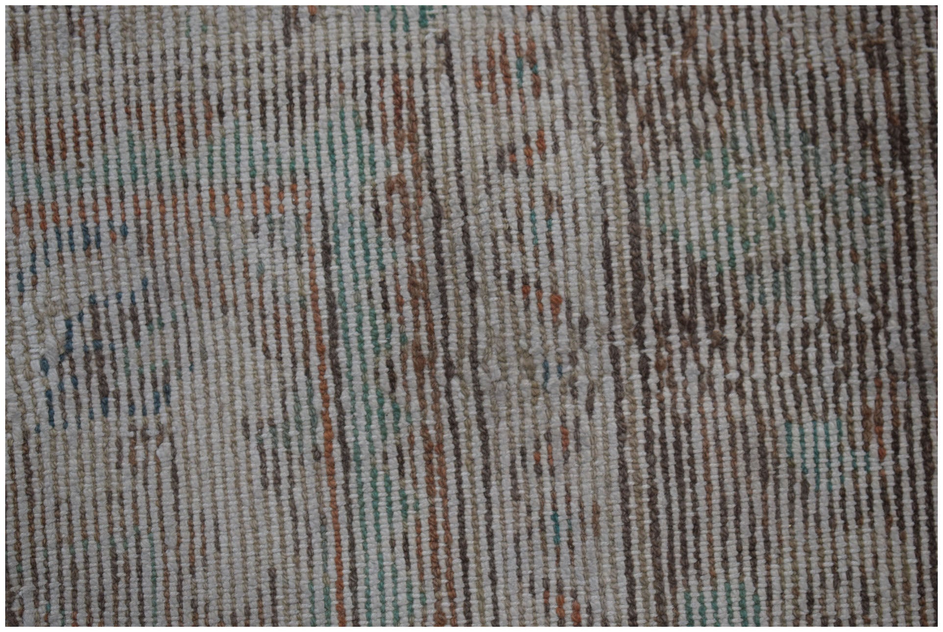A close-up of a vintage Persian Sarouk rug featuring a faded, handwoven pattern in wool.