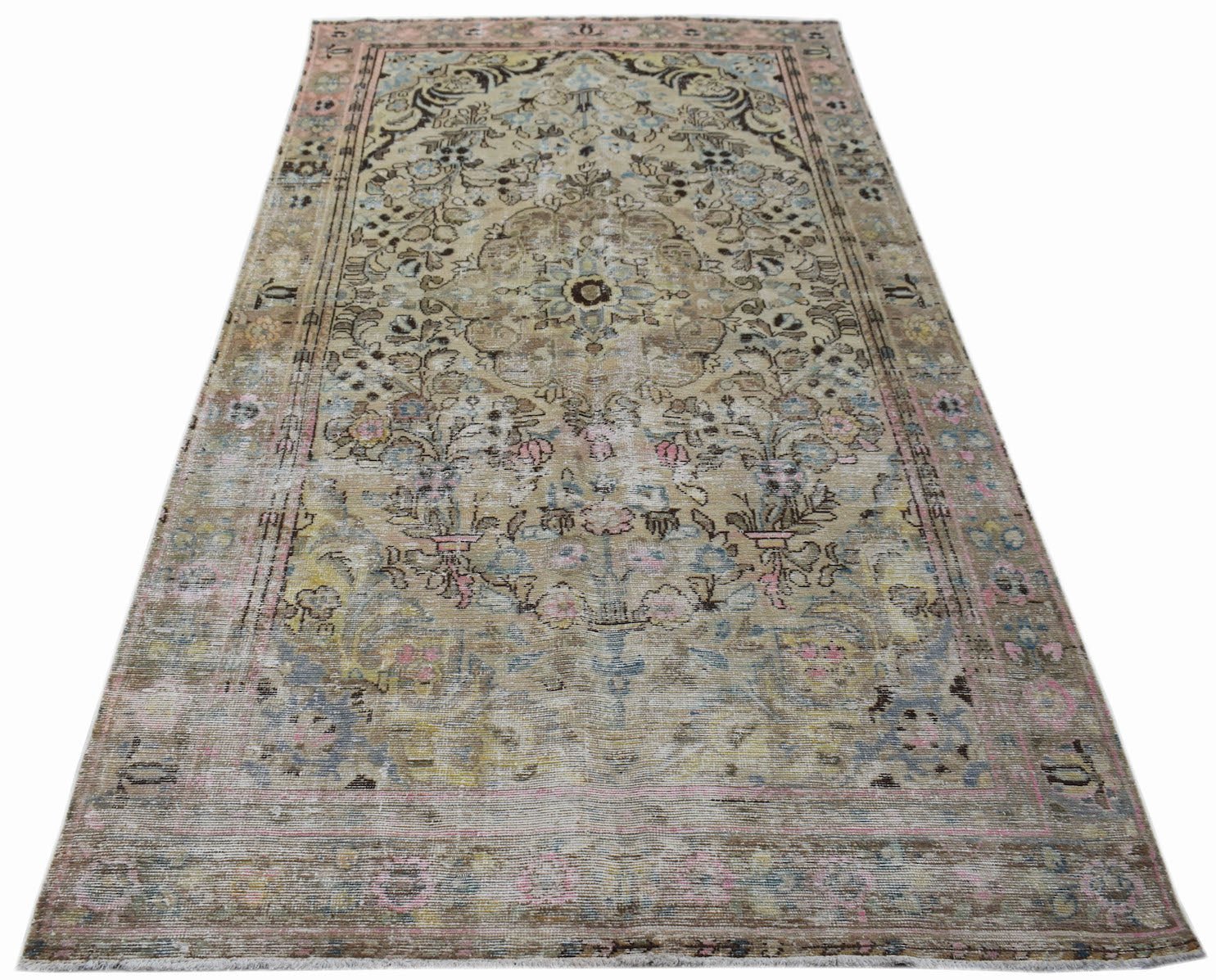 A vintage Persian Sarouk rug featuring a faded floral medallion pattern in muted earth tones.