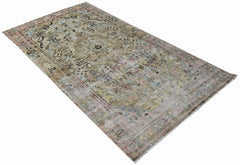 A vintage Persian Sarouk rug featuring a faded floral pattern in muted earth tones and soft pinks.