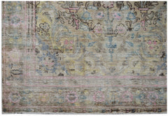 A vintage Persian Sarouk rug featuring a faded floral pattern in muted pink, blue, and yellow tones.