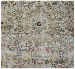 A vintage Persian Sarouk rug featuring a faded floral pattern in muted earth tones.