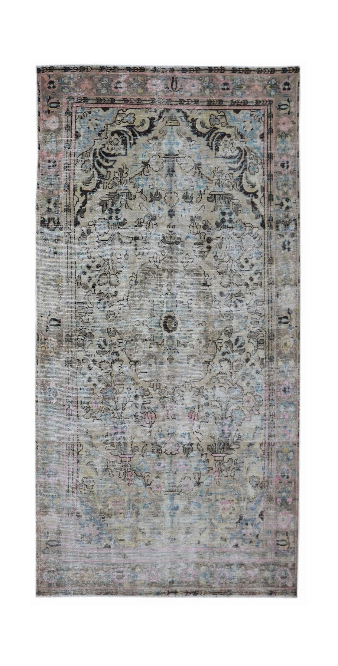 A vintage Persian Sarouk rug featuring a faded floral medallion pattern in muted earth tones.