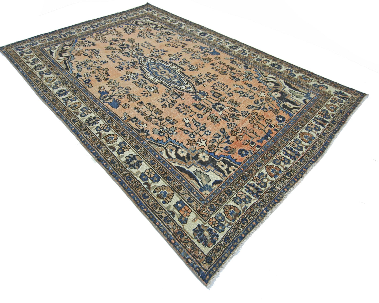 A vintage Persian Sarouk rug featuring a floral pattern in shades of peach, blue, and cream.