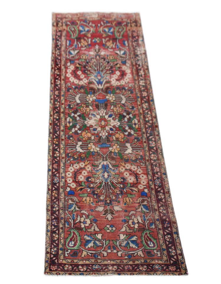 A vintage Persian Sarouk runner featuring a floral pattern on a red field with a dark border.