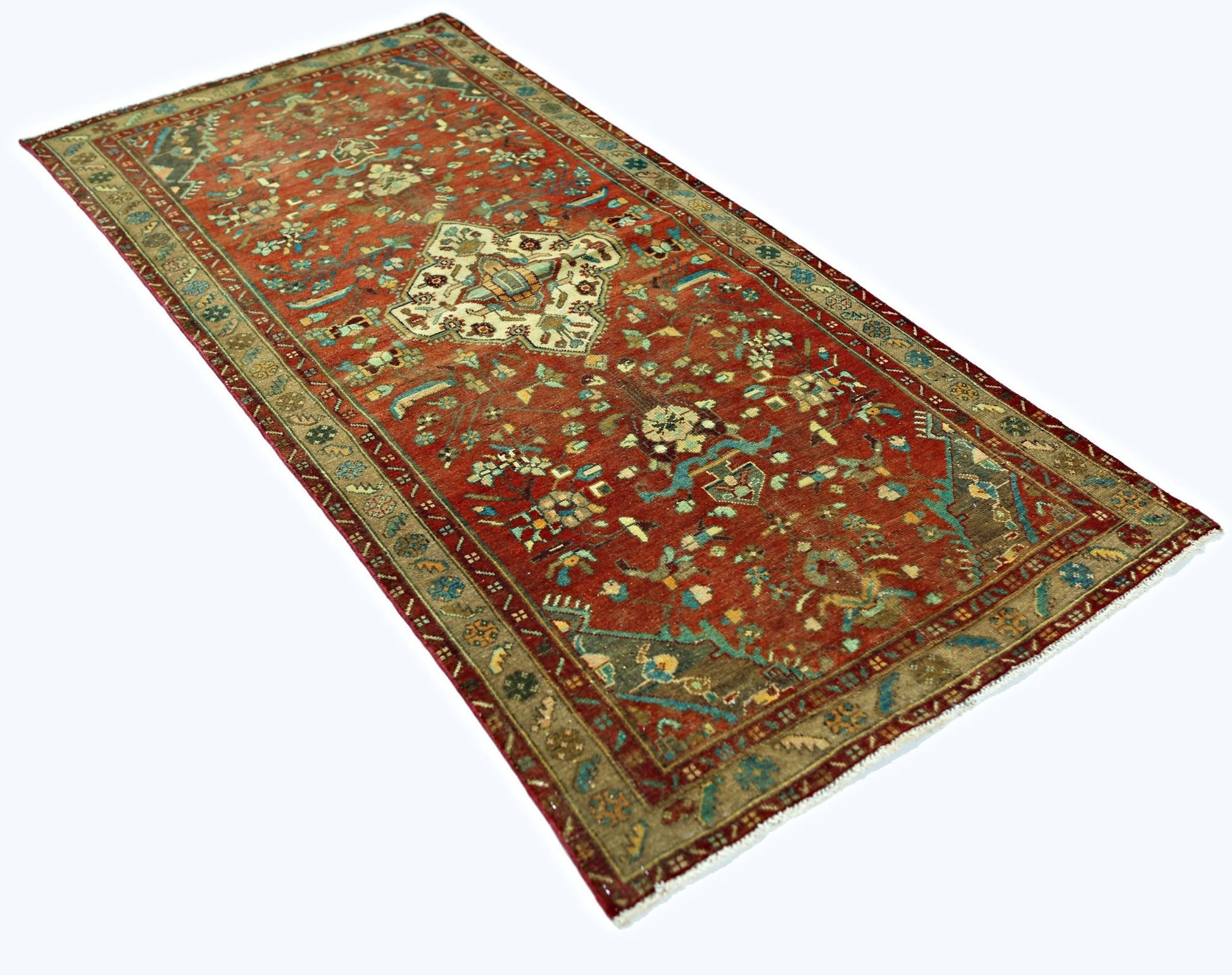 A vintage Persian Sarouk rug featuring a floral pattern in red, blue, and beige tones.