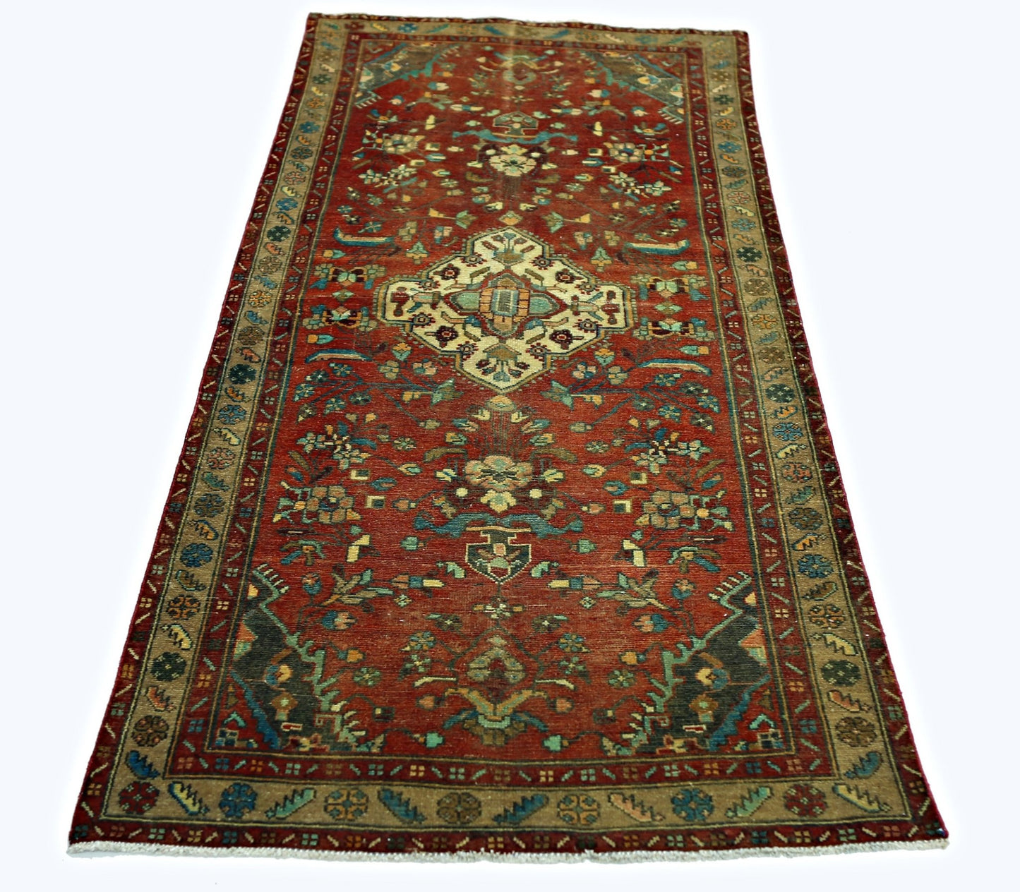 A vintage Persian Sarouk rug featuring a central floral medallion on a red field with tan borders.