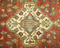 A vintage Persian Sarouk rug featuring a central floral medallion on a rust-red background.