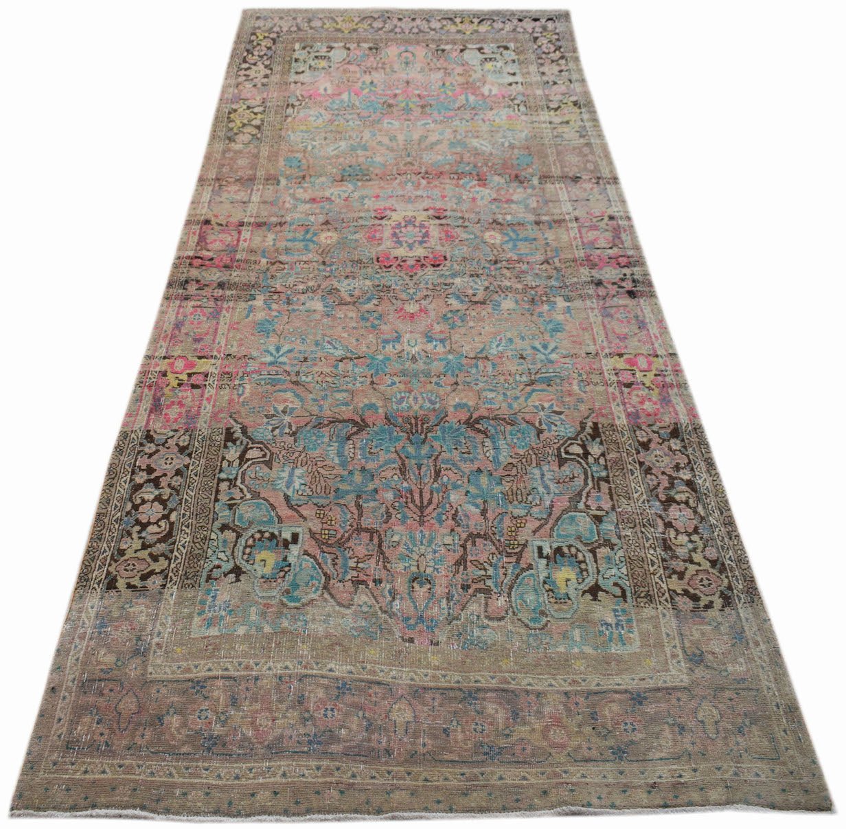 A vintage handwoven Persian runner rug featuring a faded floral pattern in pink and blue tones.