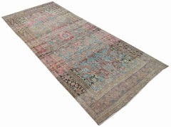 A vintage handwoven Persian rug featuring a faded floral pattern in shades of pink and blue.