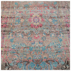 A vintage handwoven Persian rug featuring a faded floral pattern in shades of pink and blue.
