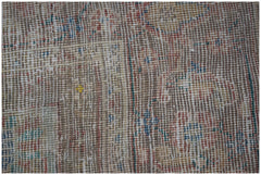 A close-up of a handwoven vintage Persian rug featuring a faded, distressed wool pattern.