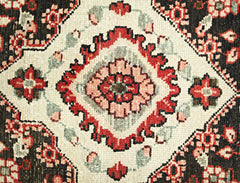 A vintage Persian Sarouk runner featuring a central floral medallion in red, pink, and cream tones.
