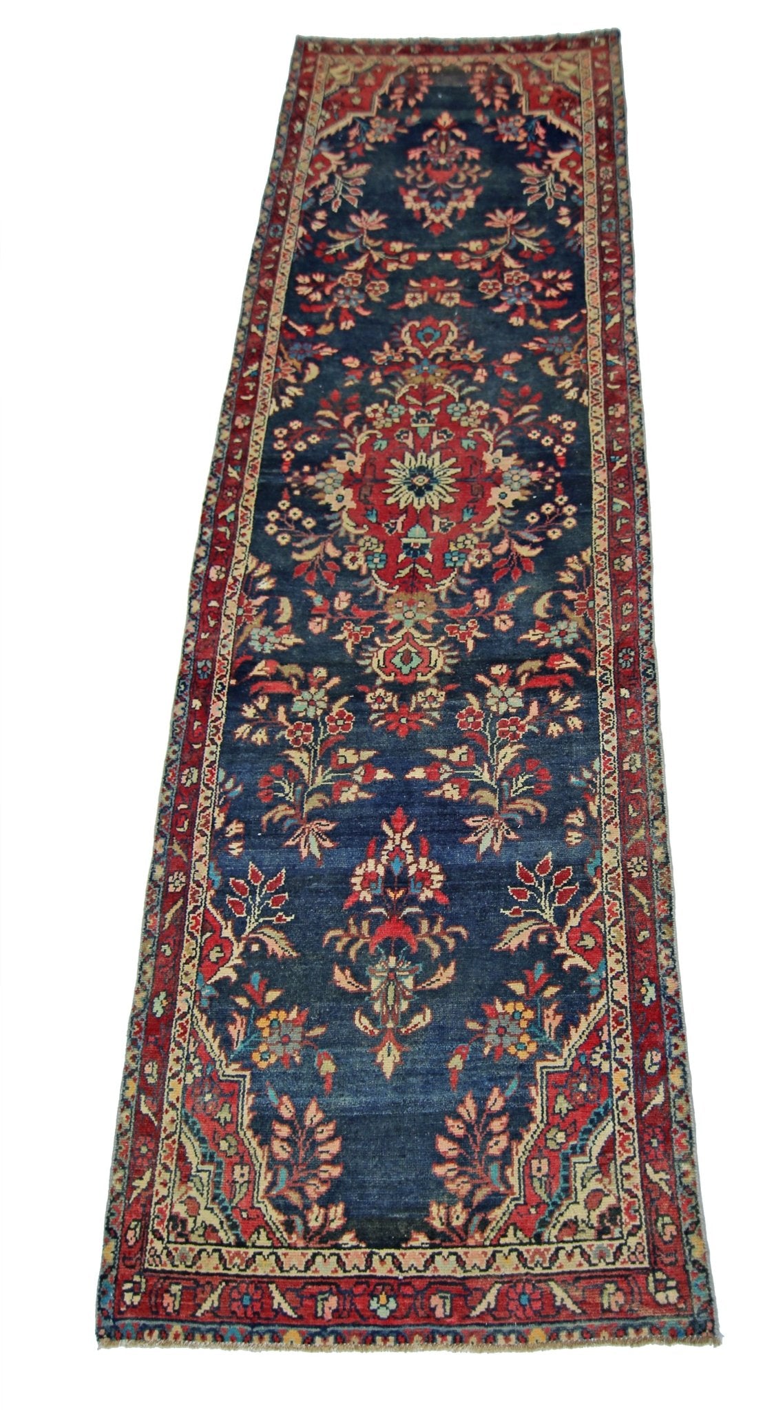 A vintage Persian Sarouk runner featuring a floral pattern in red and blue on a dark blue field.