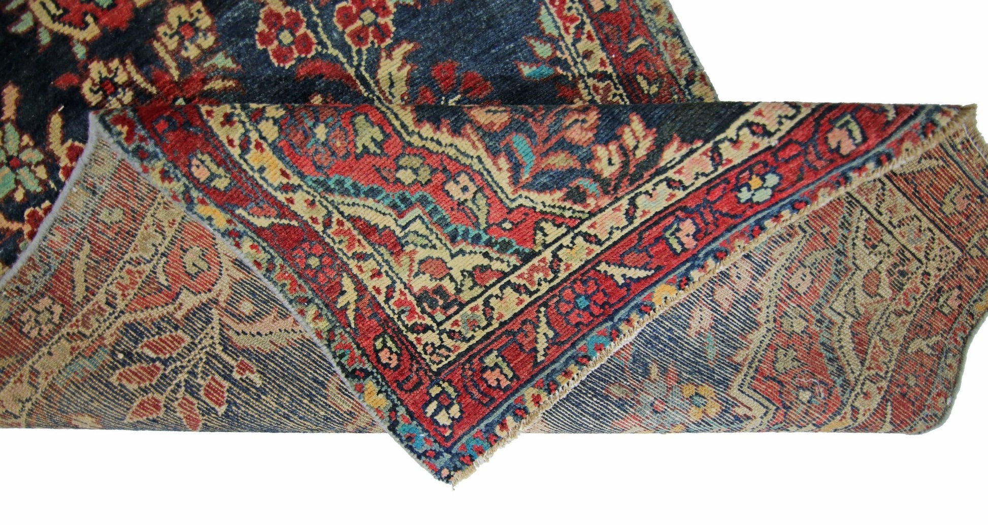 A vintage Persian Sarouk runner with a floral pattern in red and blue on a cotton base.