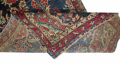 A vintage Persian Sarouk runner with a floral pattern in red and blue on a cotton base.