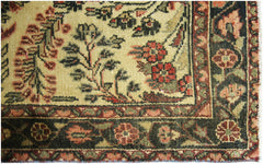 A close-up of a vintage Persian Sarouk runner featuring intricate floral patterns in wool.