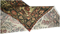 A vintage Persian Sarouk runner with a floral pattern in red, green, and cream wool.