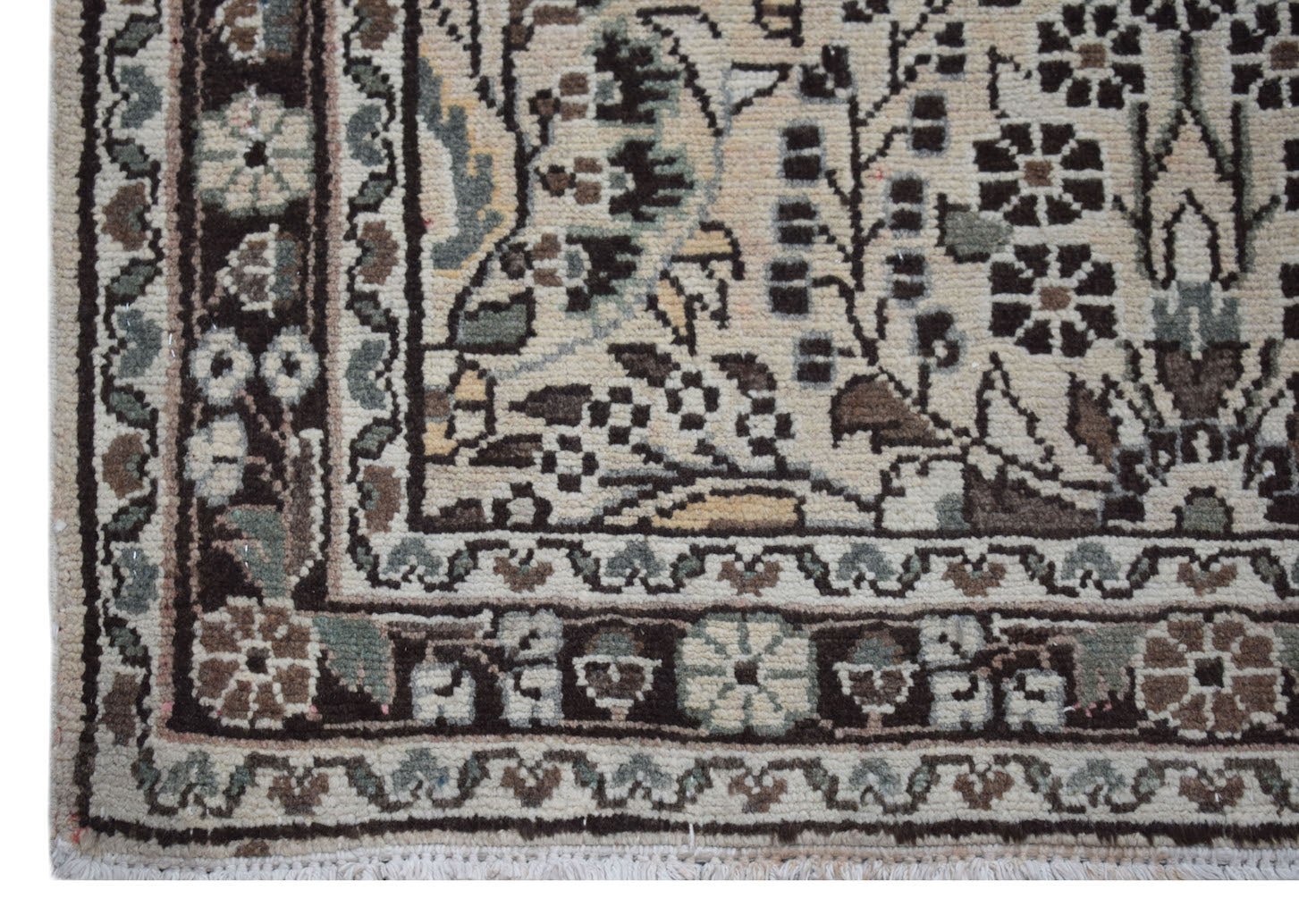 A close-up of a vintage Persian Sarouk runner featuring intricate floral patterns in wool.