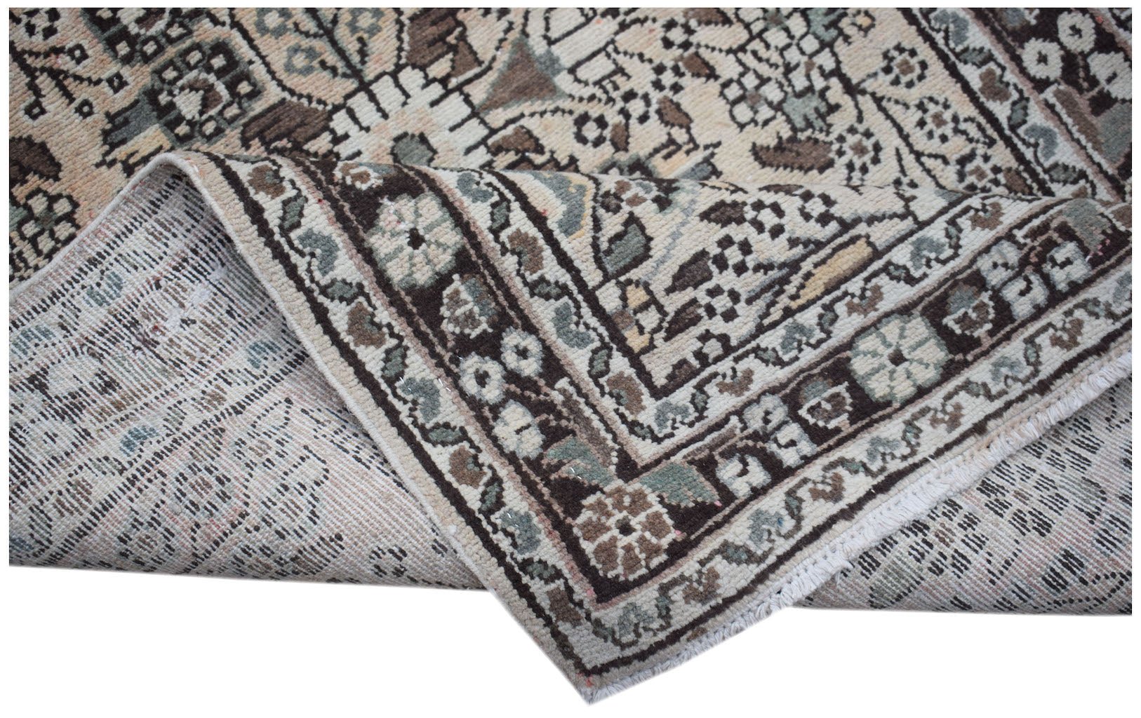 A vintage handwoven Persian Sarouk runner featuring a floral pattern in muted earth tones.