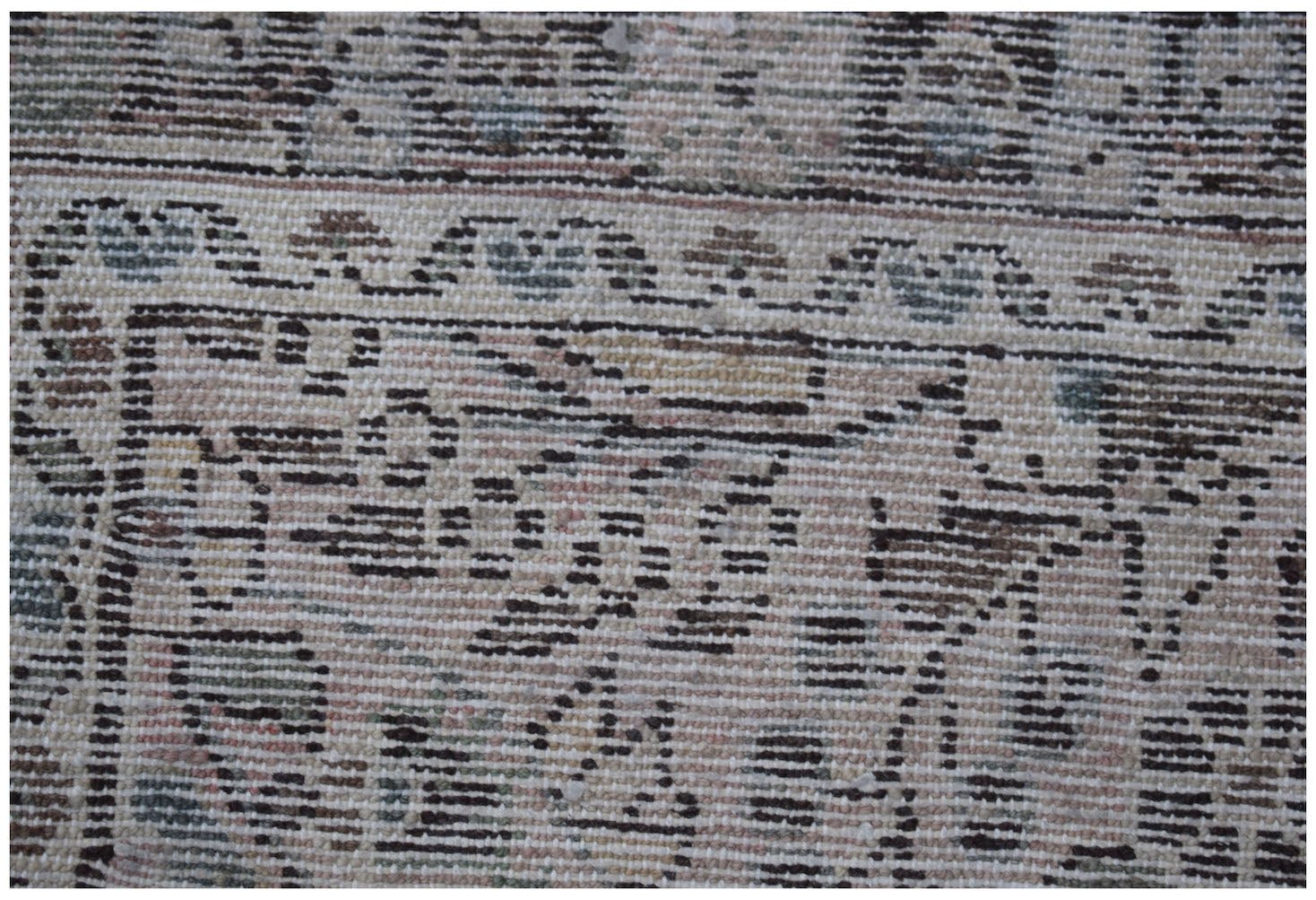 A close-up of a vintage Persian Sarouk runner featuring intricate floral patterns in muted tones.