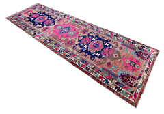Vintage Persian Saveh runner featuring vibrant pink and navy blue geometric floral motifs on a hand-knotted wool pile.