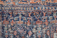 A vintage Persian rug featuring a detailed floral pattern in shades of blue, orange, and cream.