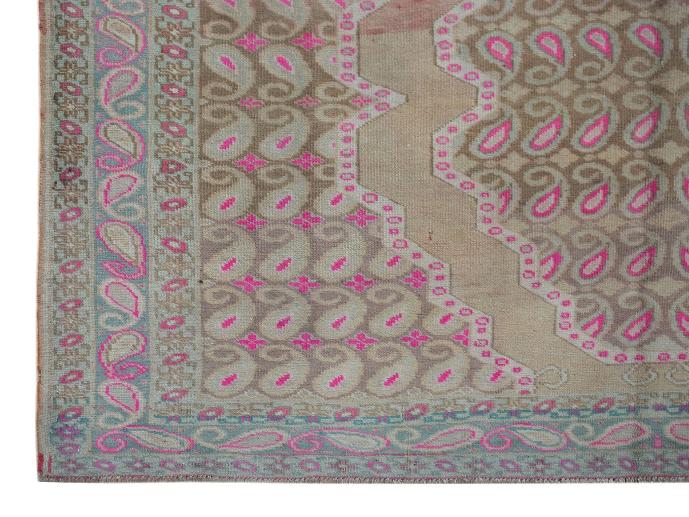 A vintage Persian Senneh rug featuring a repeating paisley pattern in pink and muted earth tones.