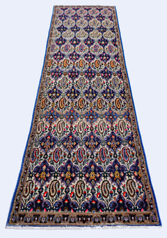 A vintage Persian Senneh runner rug featuring a repeating paisley pattern in vibrant colors.