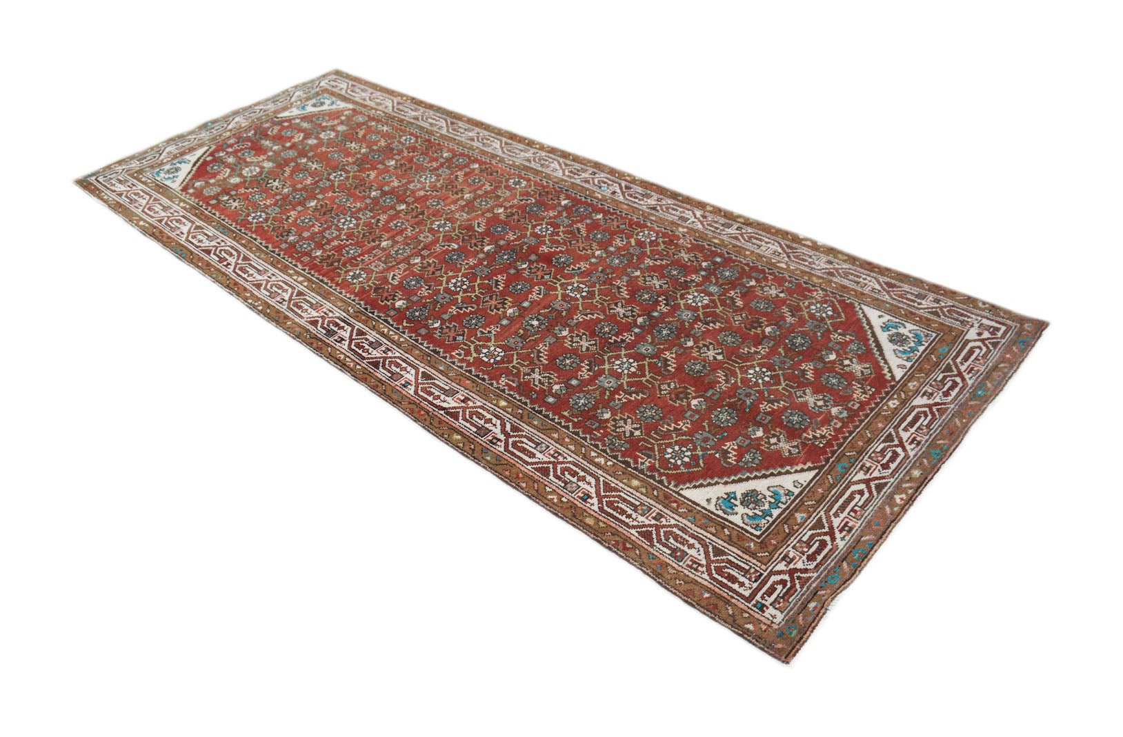 A handwoven vintage Persian Senneh runner featuring a red field with intricate geometric patterns.