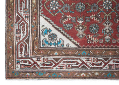 A vintage Persian Senneh runner featuring a red field with intricate geometric floral patterns.