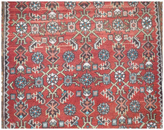 A vintage Persian Senneh runner featuring a geometric floral pattern in red, blue, and cream tones.