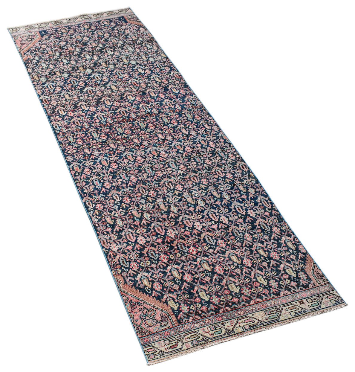 A vintage Persian Senneh runner rug featuring a dark blue field with intricate floral patterns.