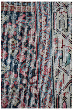A close-up of a vintage Persian Senneh runner featuring intricate floral patterns in wool.