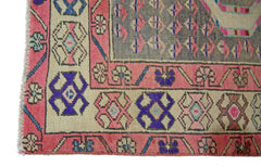 A vintage Persian Senneh runner featuring a geometric pattern in pink, blue, and grey wool.