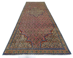 A vintage Persian Senneh runner featuring a geometric pattern in red, blue, and beige tones.