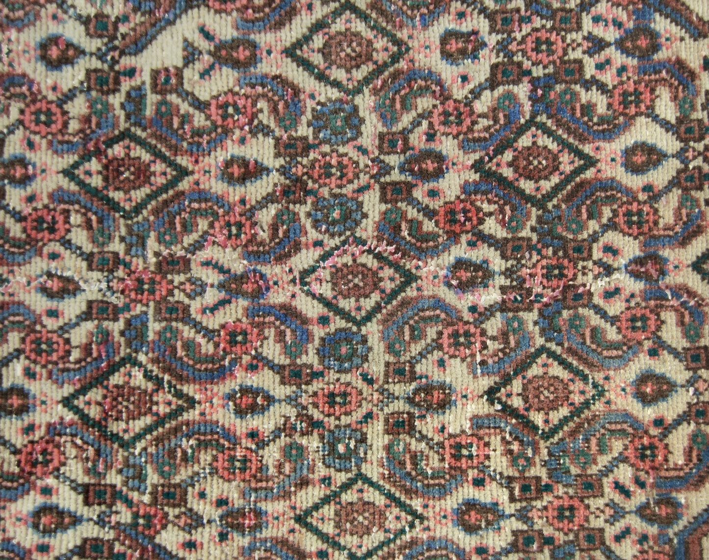 A vintage Persian Senneh runner featuring a detailed geometric pattern in wool on a cotton base.