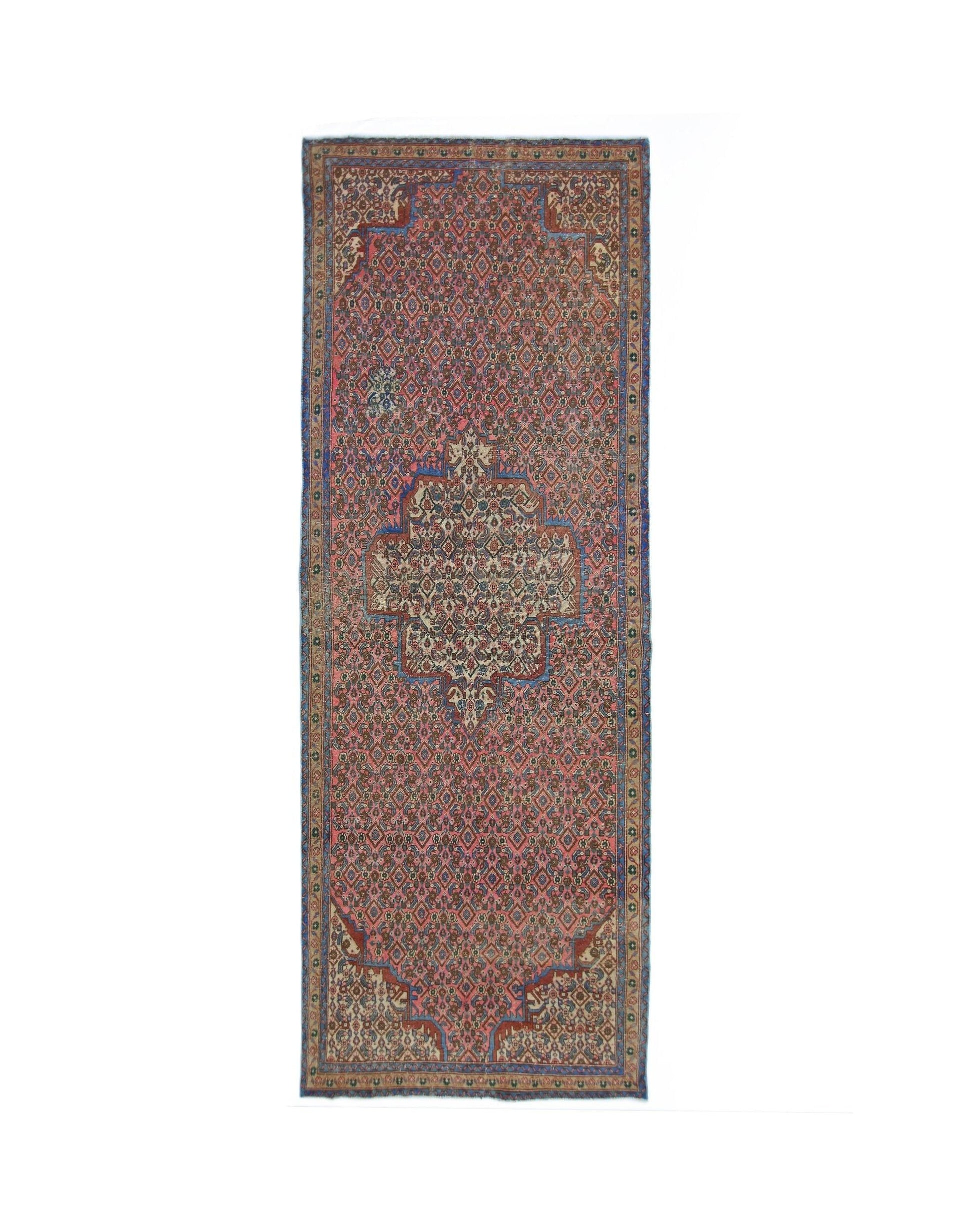 A vintage Persian Senneh runner featuring a central medallion on a patterned rose-colored field.