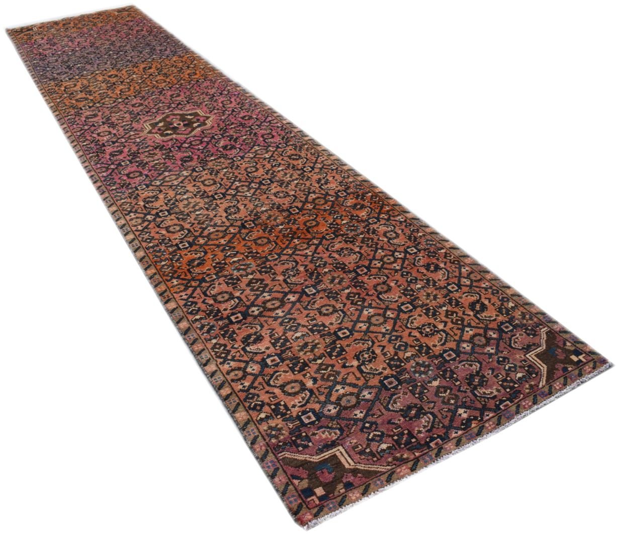 A vintage Persian Senneh runner rug featuring a geometric pattern in shades of red and blue.