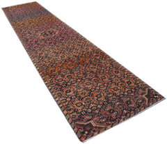 A vintage Persian Senneh runner rug featuring a geometric pattern in shades of red and blue.