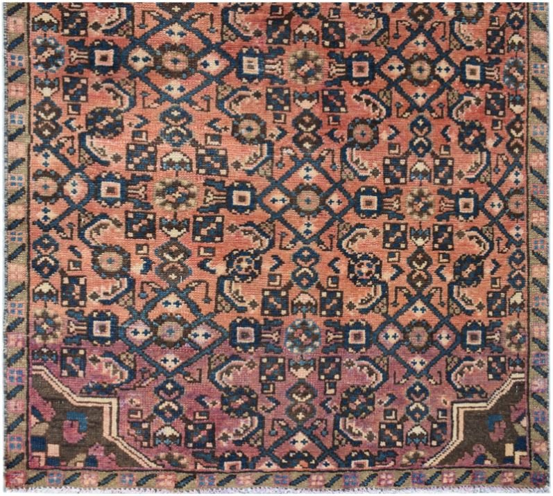 A vintage Persian Senneh runner featuring a geometric diamond pattern in red, blue, and brown.