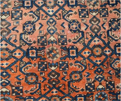 A vintage Persian Senneh runner featuring a geometric floral pattern in shades of orange and blue.