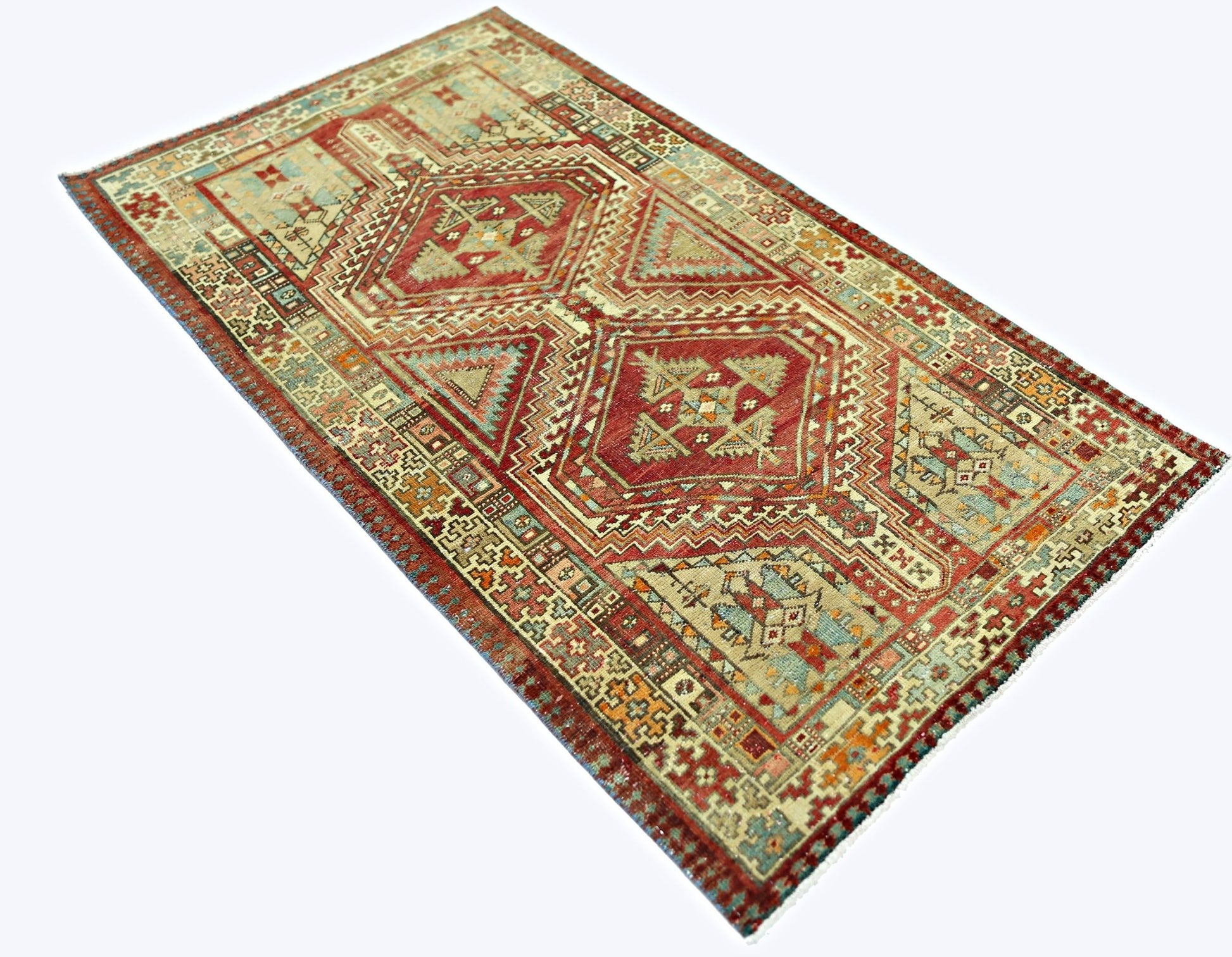 A rectangular vintage Persian rug featuring geometric diamond patterns in red, beige, and blue.
